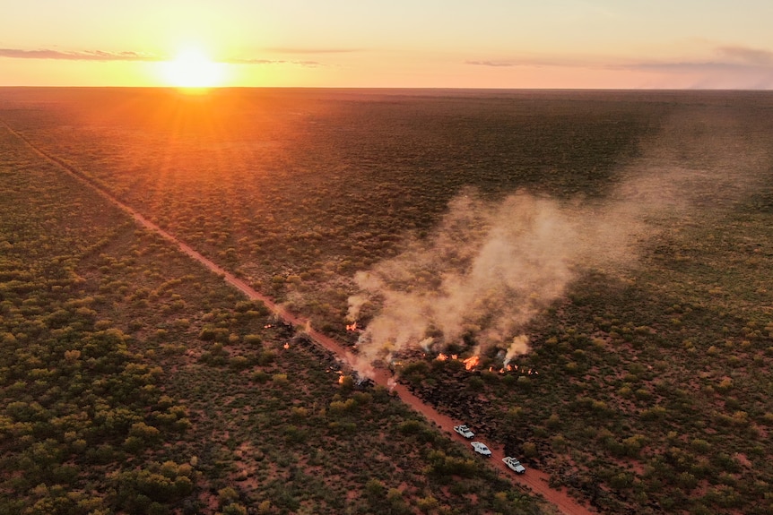 Fire burns at sunset in the desert.