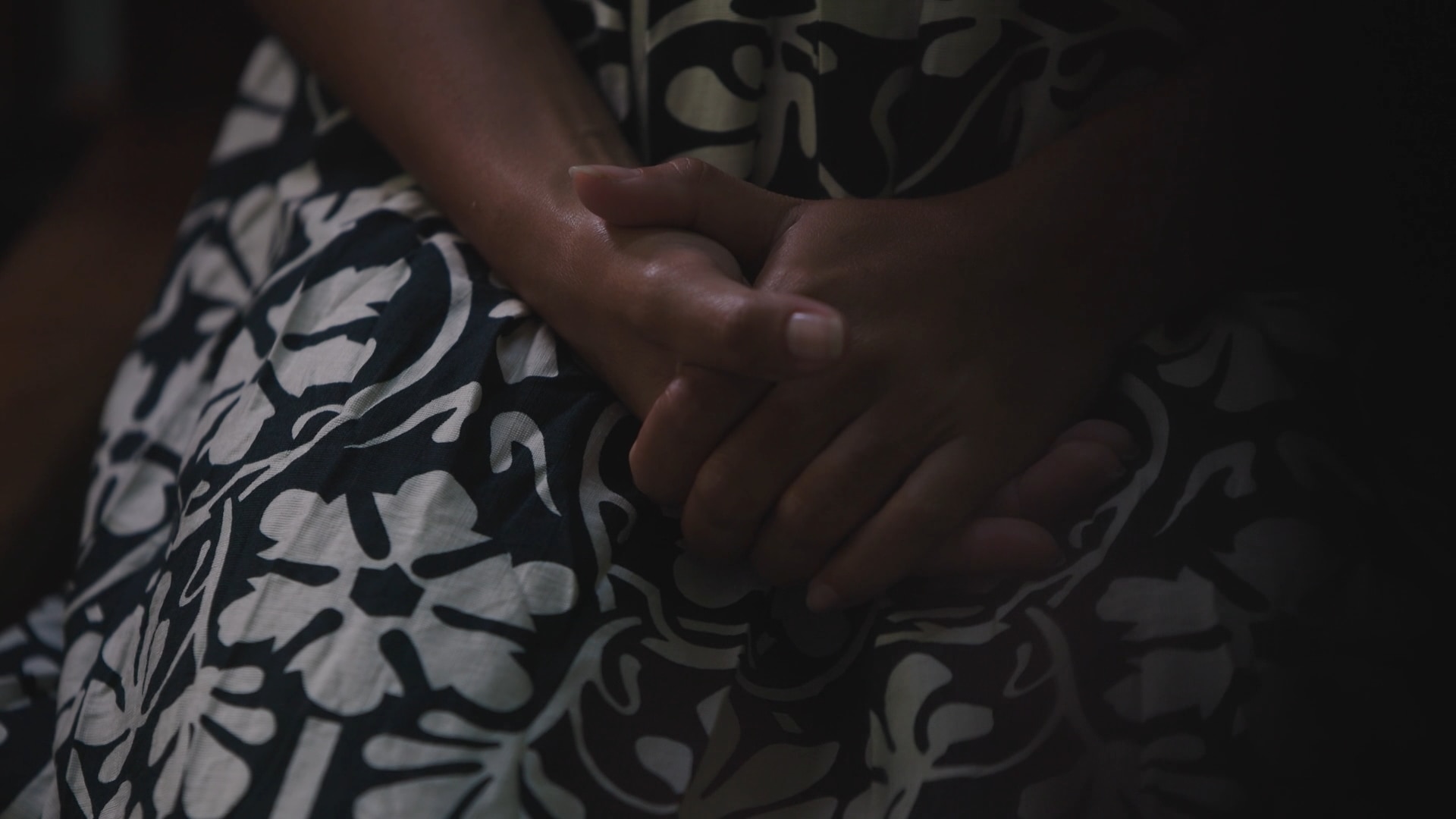 A woman's hands sitting in her lap.