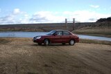 A car parked at the bottom of Wyangala Dam near Cowra NSW shows how low the storage has fallen in recent years