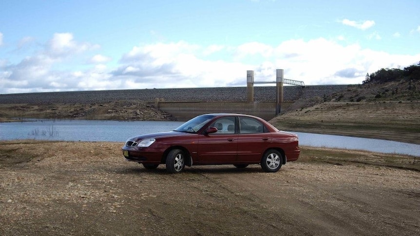 A car parked at the bottom of Wyangala Dam near Cowra NSW shows how low the storage has fallen in recent years