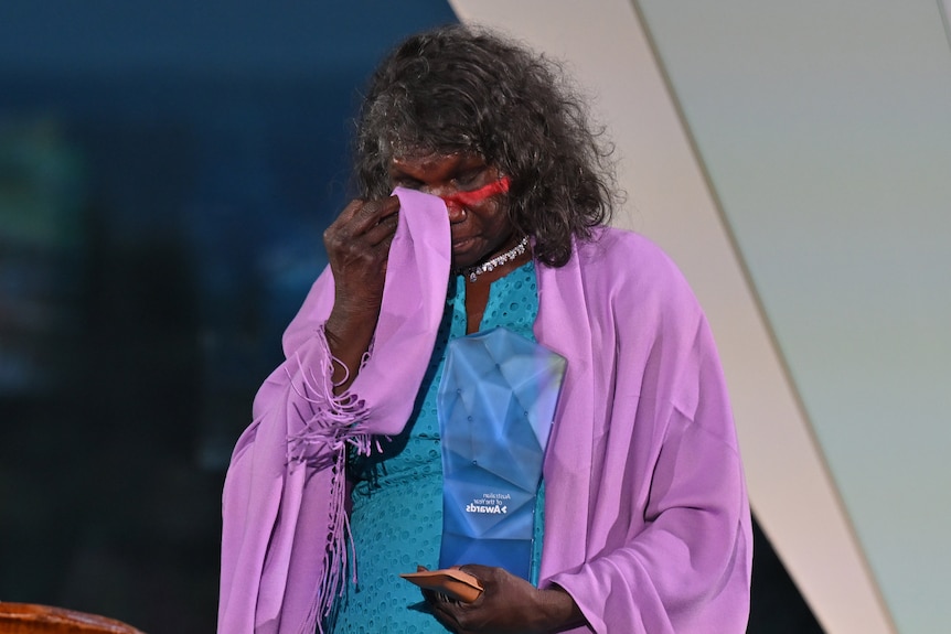 Una mujer indígena aceptando un premio.