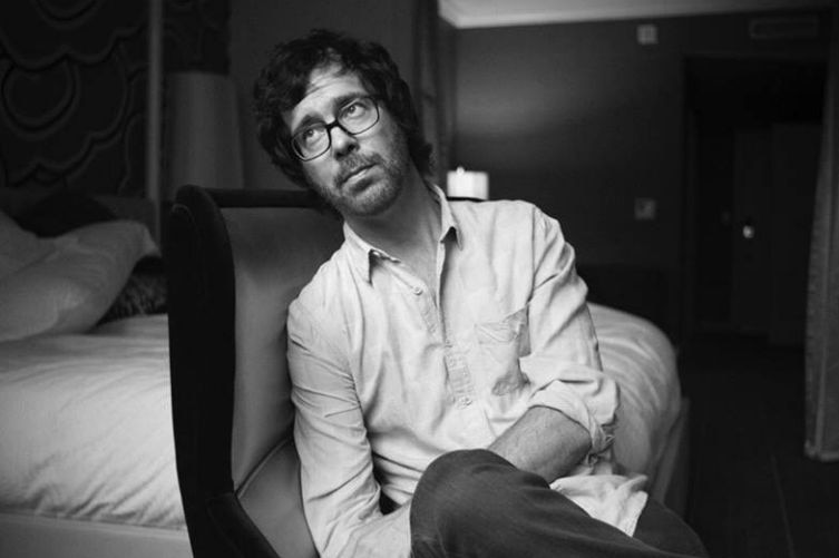 Ben Folds sits in a chair in a hotel room