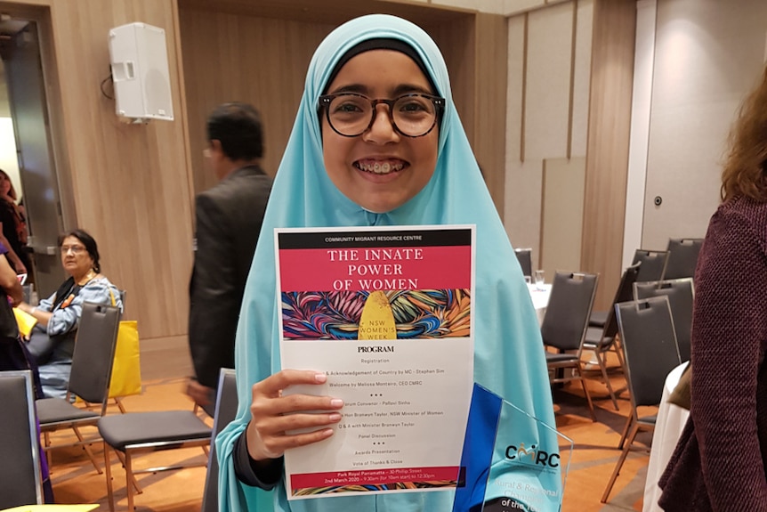 Girl holding an award trophy.