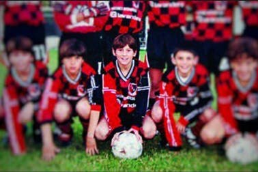A small Lionel Messi in the middle of a team photo with other boys.
