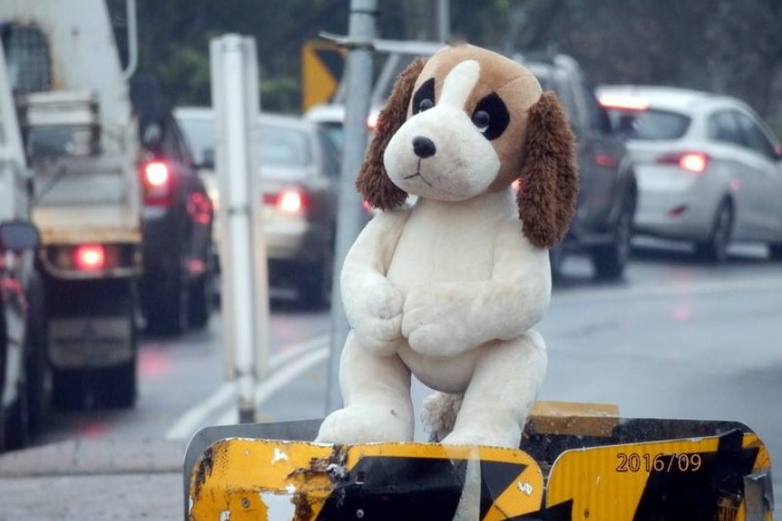 A stuffed dog sitting on a roundabout.