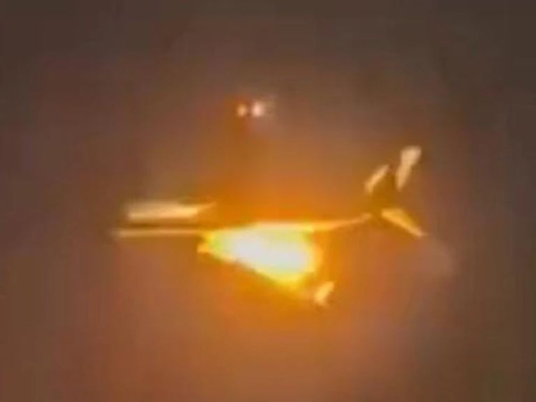 A blurry photo of a plane with a flame coming from it.