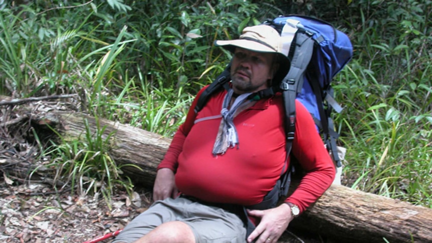 Peter FitzSimons lays against a log during the Kokoda Trail walk in 2002.