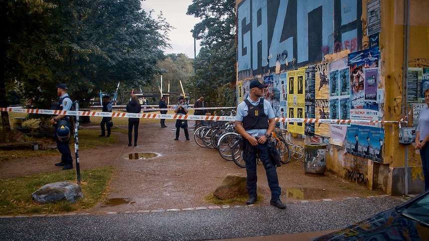 Police outside a building with police tape around it