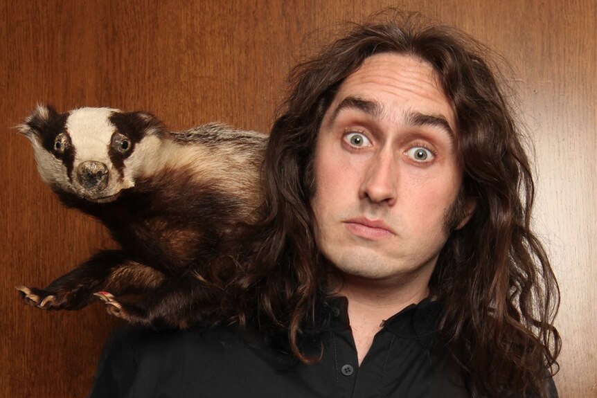 Comedian Ross Noble with a stuffed skunk.