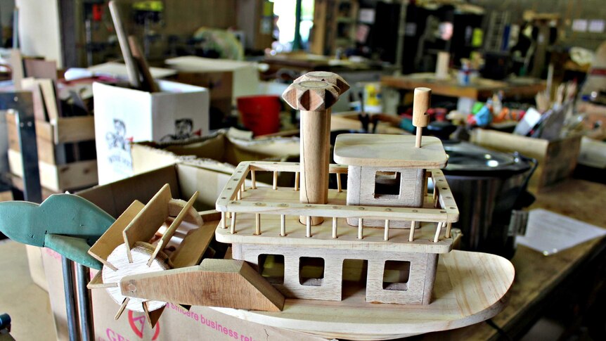 Handmade wooden boat toy sitting in Mr Smith's workshop.