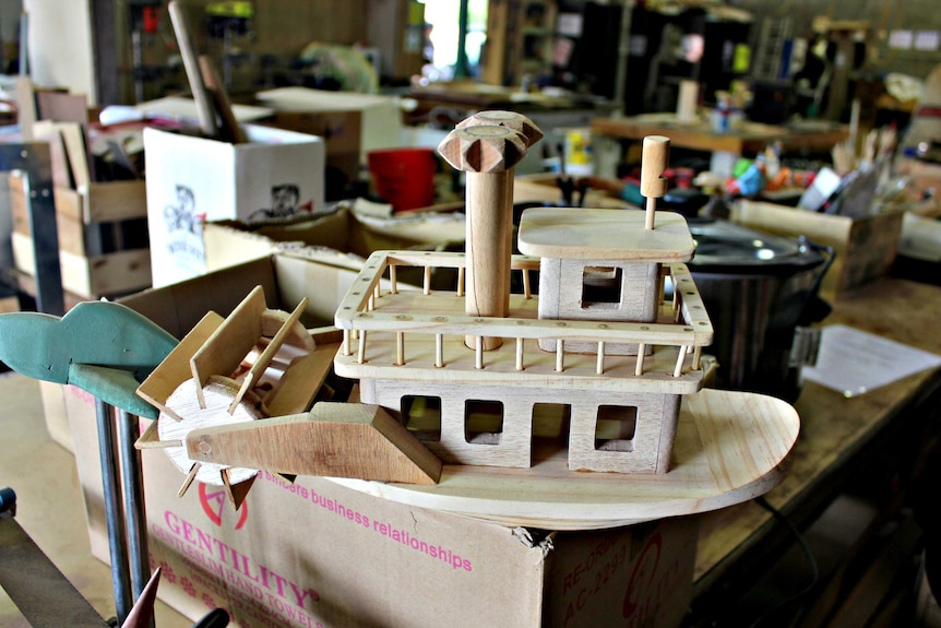 Handmade wooden boat toy sitting in Mr Smith's workshop.