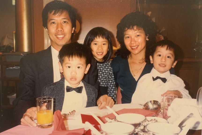 Australian travel writer Jasmine Sue sits with her parents and brothers in a restaurant.