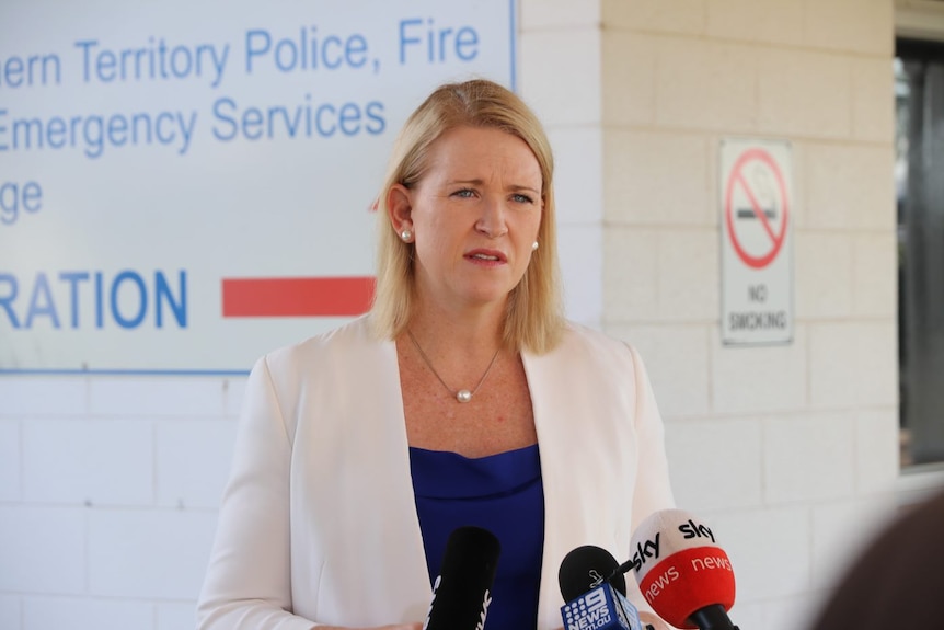 NT Police Minister Nicole Manison wears a white blazer and a blue shirt and speaks at a press conference in Darwin. 