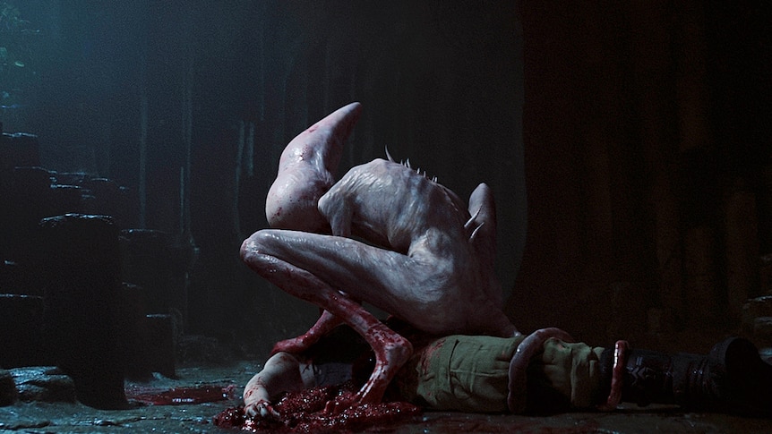 A pale creature with spikes coming out of its back hovers over a bloody body.