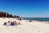 People sunbaking at Glenelg Beach.