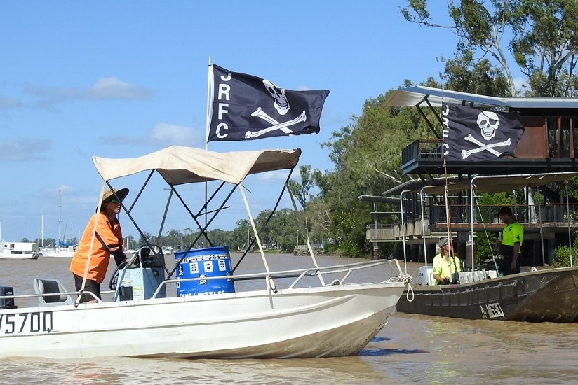 Members of the Jolly Rogers Fishing Club sail along the Fitzroy River in Rockhampton looking for rubbish