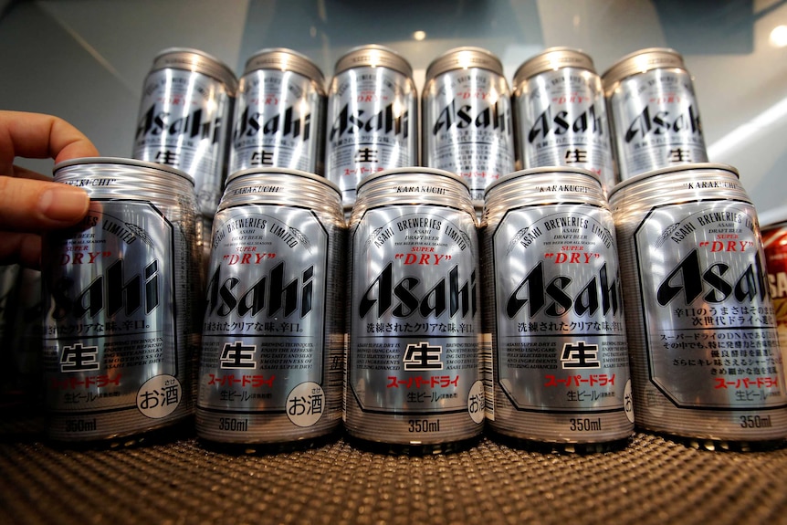 A close up of silver cans of Asahi beers stacked on top of each other.
