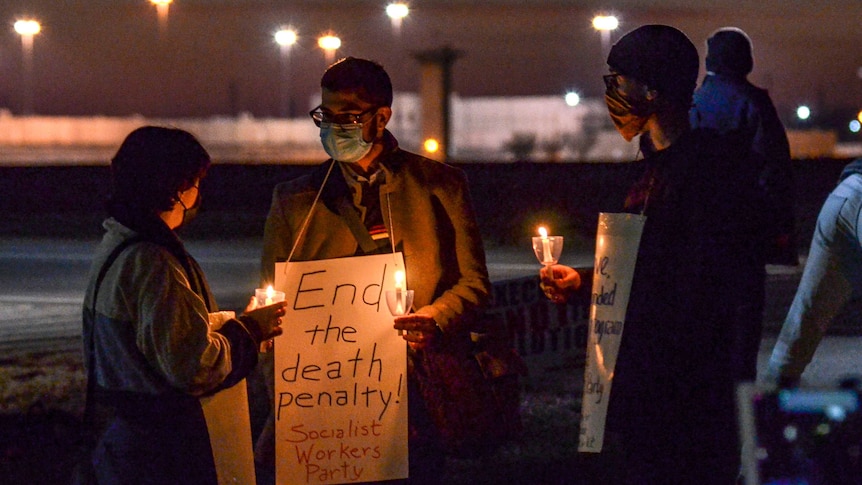 Protesters at a candlelight vigil hold up placards that read End the death penalty! Socialist Workers Party