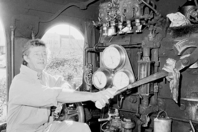 Um homem trabalha em um trem a vapor.