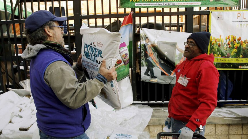 A customer carries out a bag of ice melt from a hardware store in Maryland.