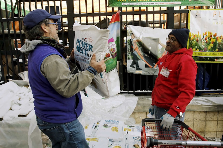 A customer carries out a bag of ice melt from a hardware store in Maryland.