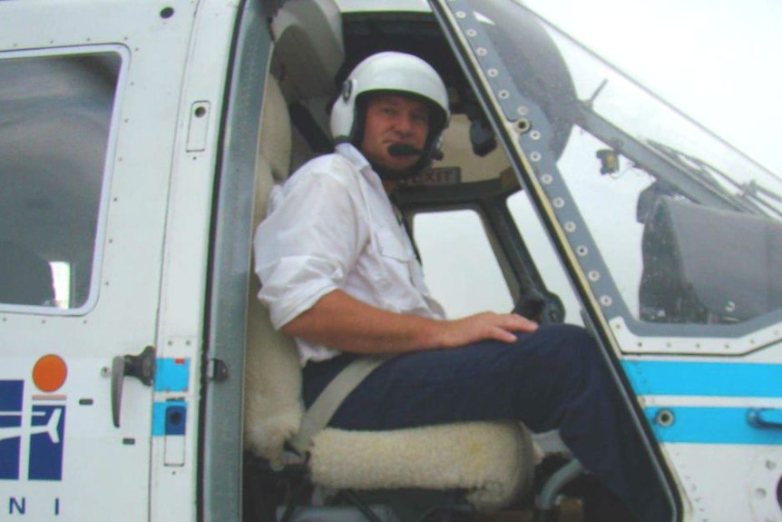 A male pilot in a helicopter