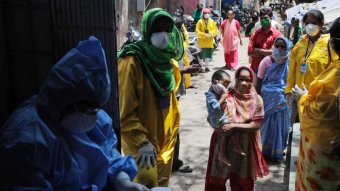 Women in India line up to be tested for coronavirus.