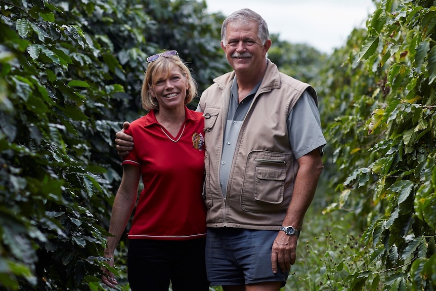 woman and man stand in coffee plantation