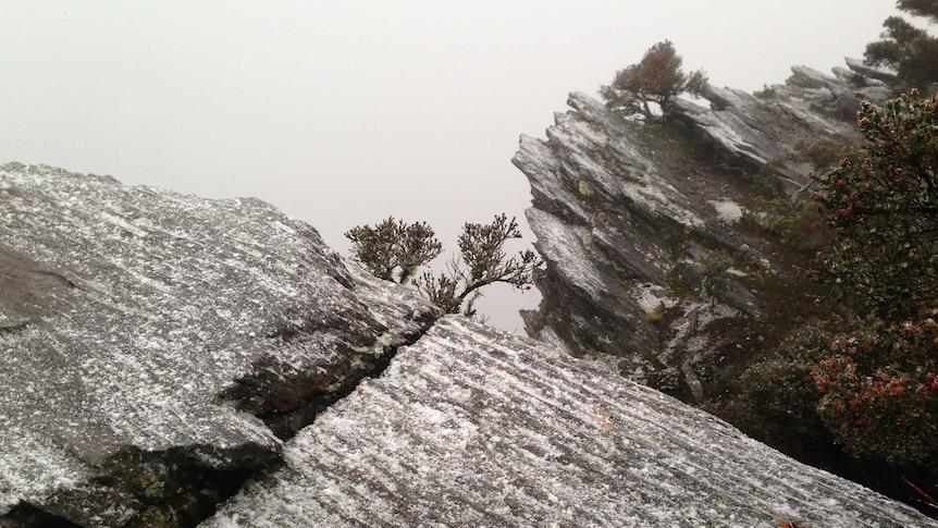 A rocky mouhntain  outcrop dusted with snow