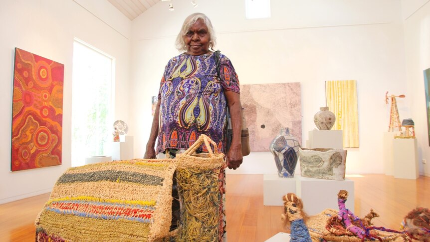 Aboriginal artist Tjunkaya Tapaya stands in front of her artwork, a woven model of a church