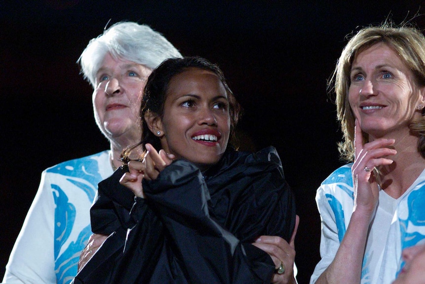 Cathy Freeman in a warm jacket after lighting the flame, with dawn fraser and Debbie Flintoff-King looking on