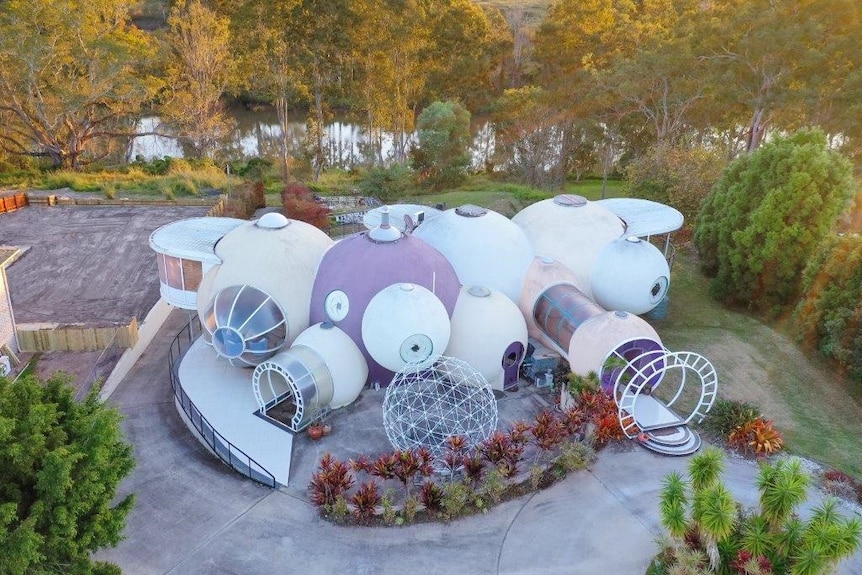 An aerial shot with the bubble house in the forefront and a river behind.