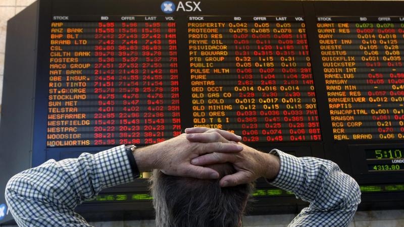 Un hombre mira hacia el tablero en la Bolsa de Valores de Australia.