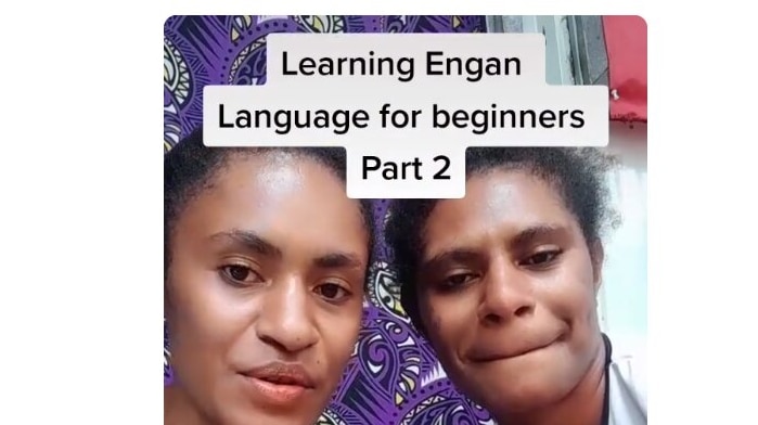 Two melanesian women talk to a camera