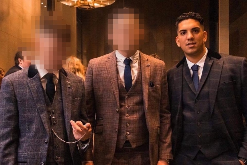 Luigi pictured with two other men wearing old-school suits pictured in a ballroom