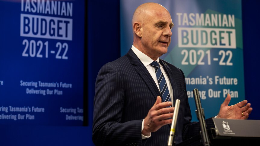 Tasmanian Premier Peter Gutwein in a blue suit speaks from a podium.