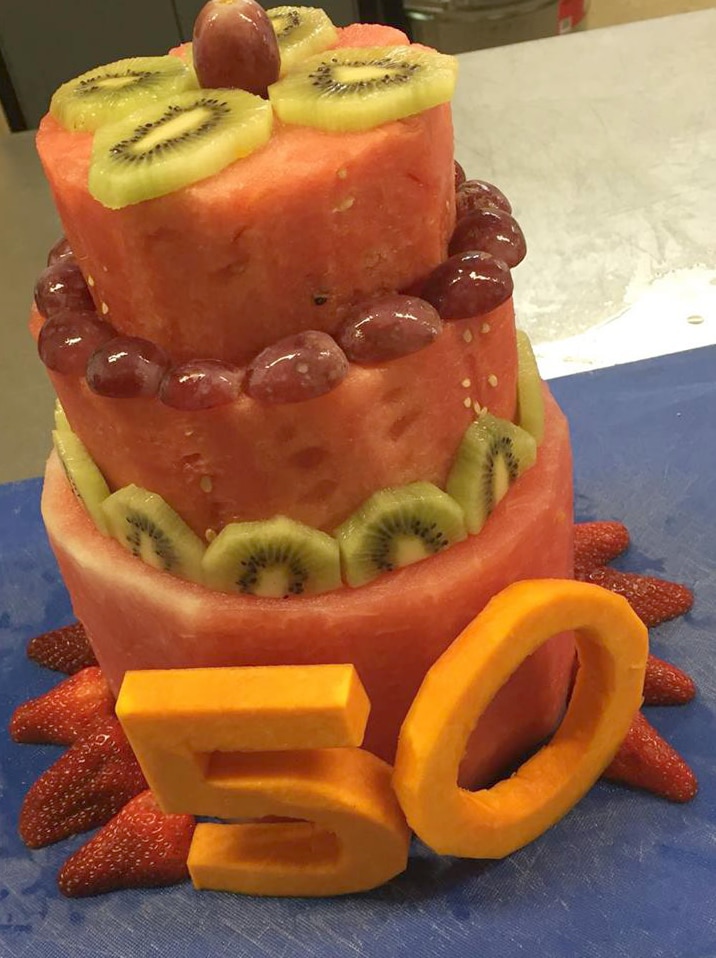 A cake made up of fruit including watermelon, kiwi fruit, pumpkin and strawberries.