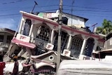 A view of a collapsed pink and white two-storey building following an earthquake, in Les Cayes, Haiti