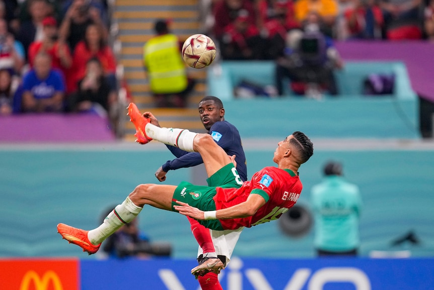 Jawad El-Yamiq  kicks the ball over his head