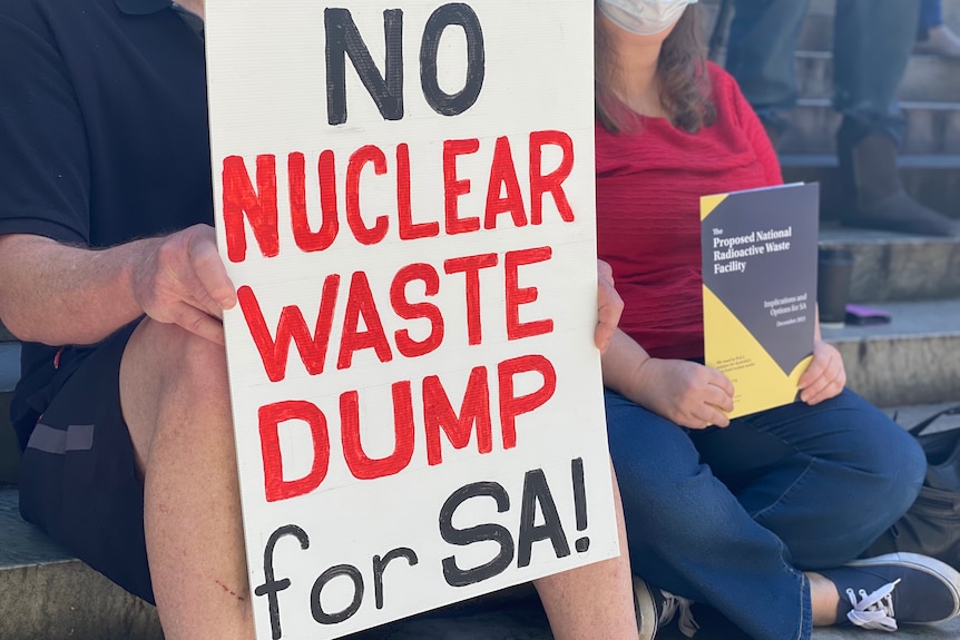 A close up of a sign with back and red words saying: No nuclear waste dump in SA