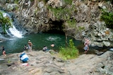 Swimmers at a hinterland waterfall and waterhole.