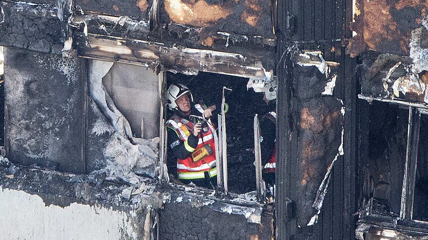 A fireman seen inside a window of the blackened tower.