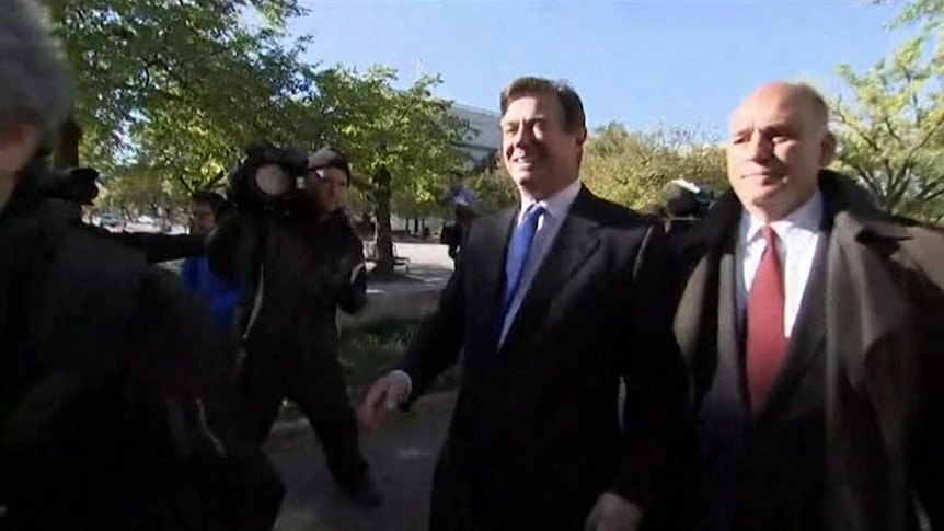 Paul Manafort (left) leaves the court after pleading not guilty to conspiracy charges