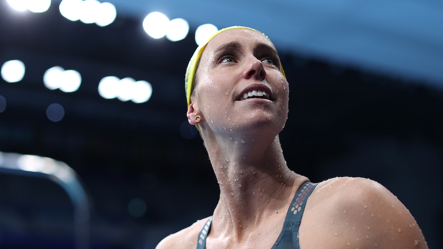 Hero shot of a swimmer with her cap on looking up to the crowd at the Olympics 