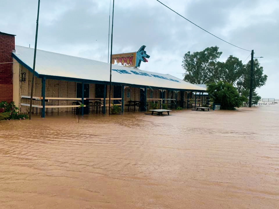 A flooded street with a pub in the foreground