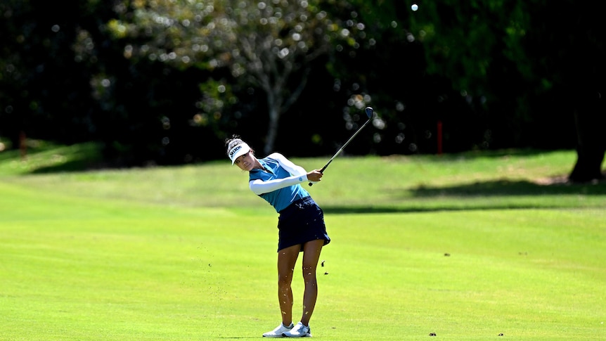 Wide angle shot of Grace Kim playing the 9th hole against the backdrop of Royal Queensland golf club
