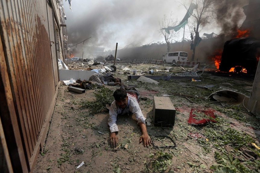A wounded man lies on the ground at the site of a blast in Kabul. 