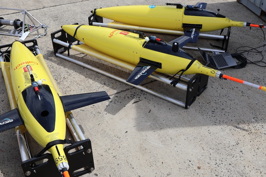 Three yellow deep-sea ocean gliders.