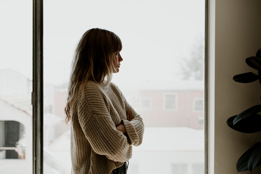 sad woman looks out window