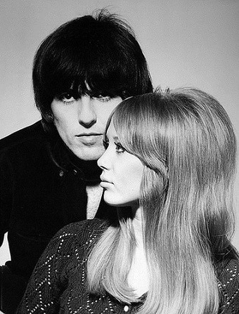 A man with black hair poses close to a women with blonde hair in a black and white photograph